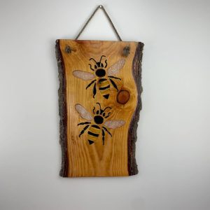 wooden hanging plaque with bees carved on
