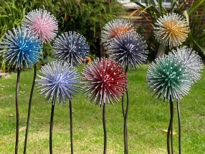 10 Dandelion Garden Stakes in 10 DIFFRENT COLOURS MAID OUT OF NAILS AND OLD GOLF BALL DISPLAYED AS ART